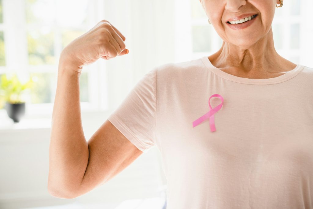 Woman with pink ribbon supporting fighting for breast cancer movement. Togetherness, oncology
